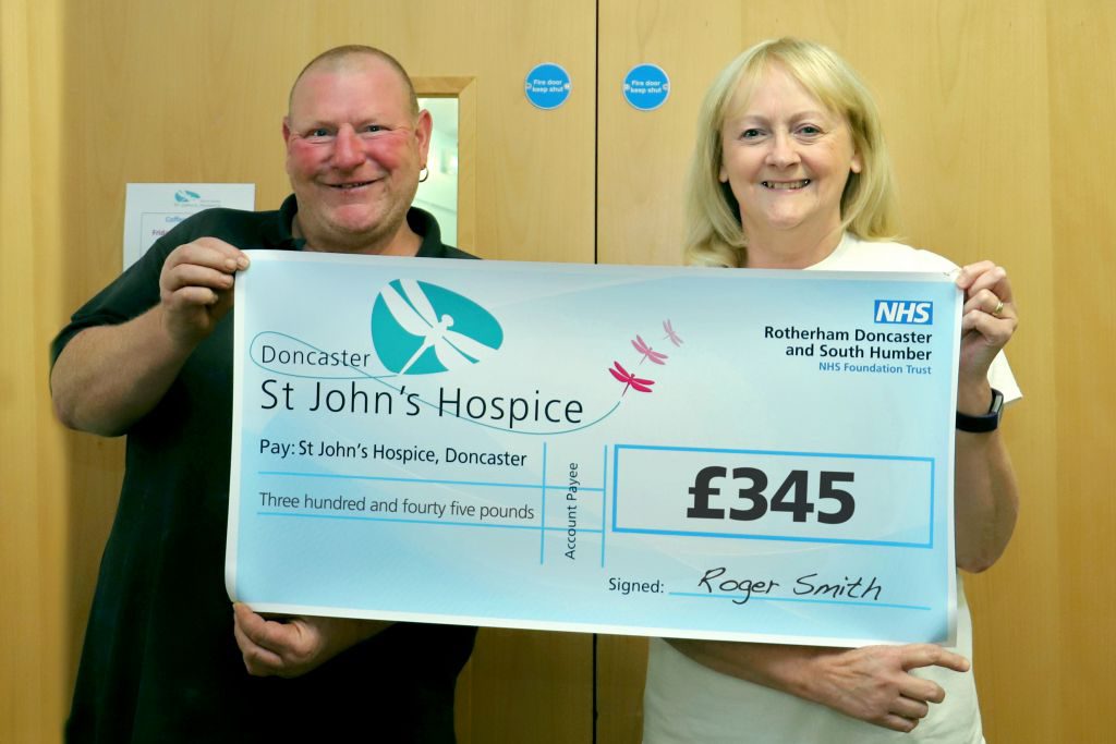 Roger is pictured handing over the cheque to Lindsey of the hospice.