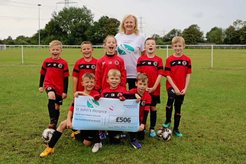 Lindsey Richards of the hospice is pictured with some of the players from Askern Miners Junior Football Club.