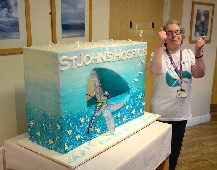 Hospice volunteer Elizabeth gives the cake a big thumbs up