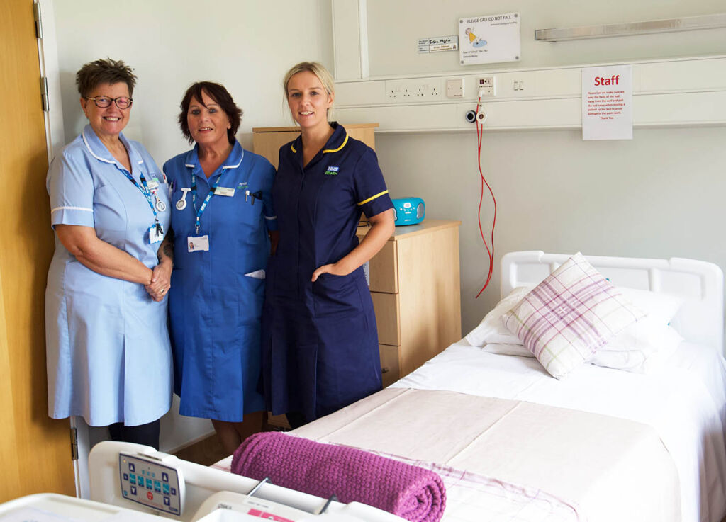Nursing staff pictured next to an inpatient bed