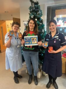 woman with two nurses with chocolate oranges in front of Christmas tree